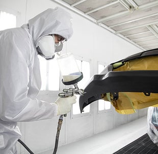 Collision Center Technician Painting a Vehicle | Woodrum Toyota of Macomb in Macomb IL