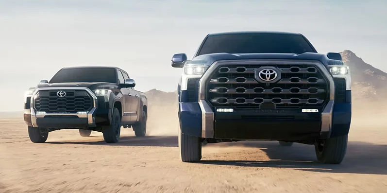 Two Toyota Tundra trucks off-roading.