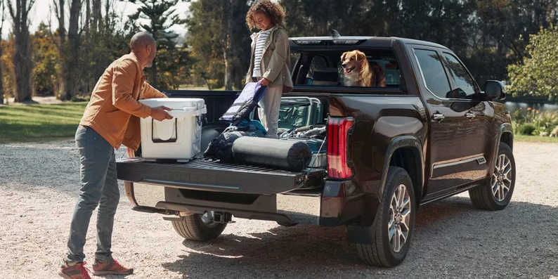 A man and his daughter packing items in to the bed of a 2025 Toyota Tundra.