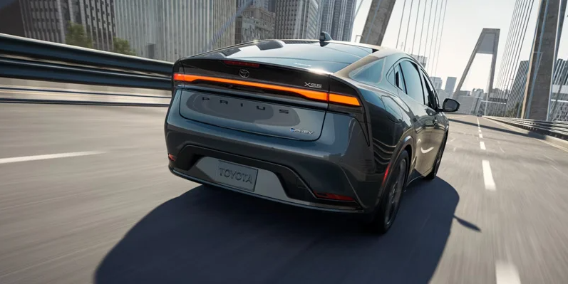 A photo of a 2025 Toyota Prius driving down the road.