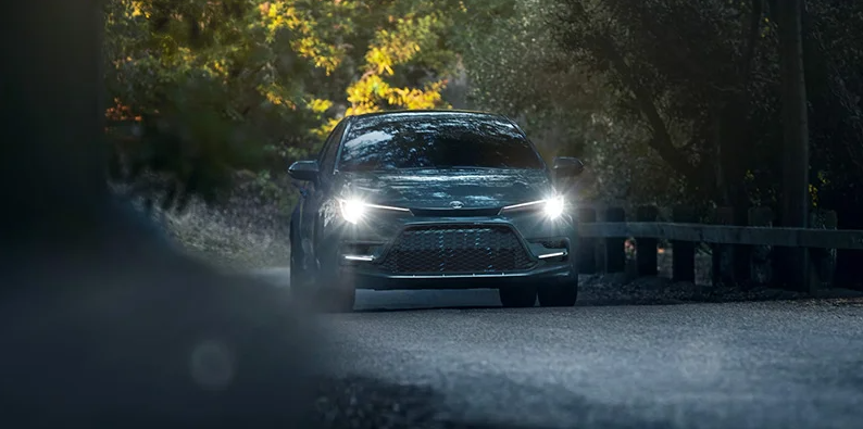 A 2025 Toyota Corolla driving down a narrow road.