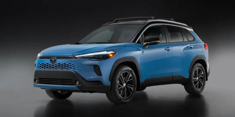 A photo of a light blue 2026 Toyota Corolla Cross with a black backround.