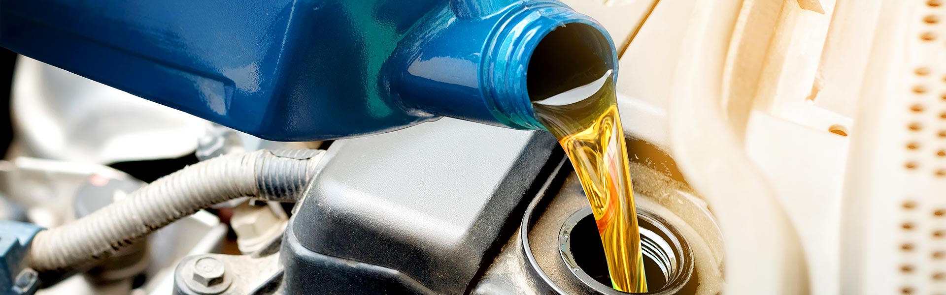 Motor oil being poured into a car engine during an oil change service