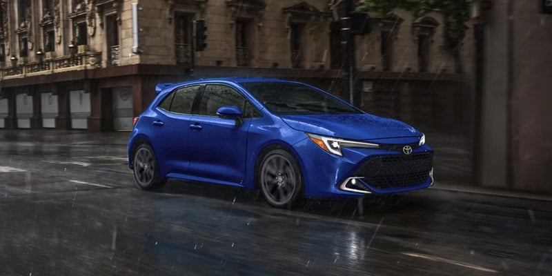 Blue 2027 Toyota Corolla Hatchback cruising on road